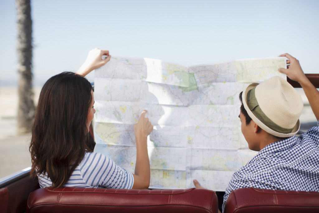 A lost couple looks at a map, illustrating how a lack of software development goals can lead to a detour on your road trip.